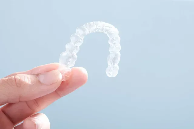 Hand holding a clear aligner