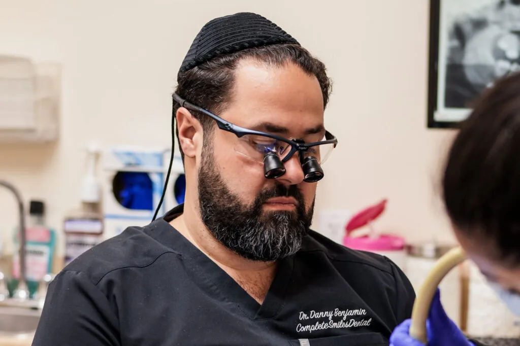 Dentist treating a patient with loupes